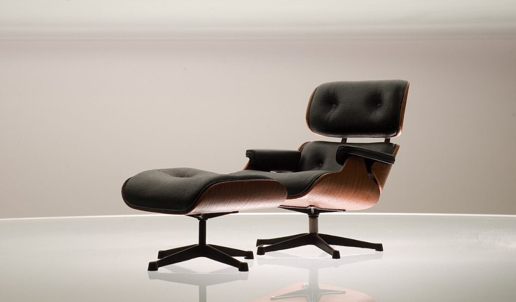 Black leather and wood Eames lounge chair with matching ottoman, sleek modern design, curved plywood frame, tufted cushions, metal swivel base, minimalist background