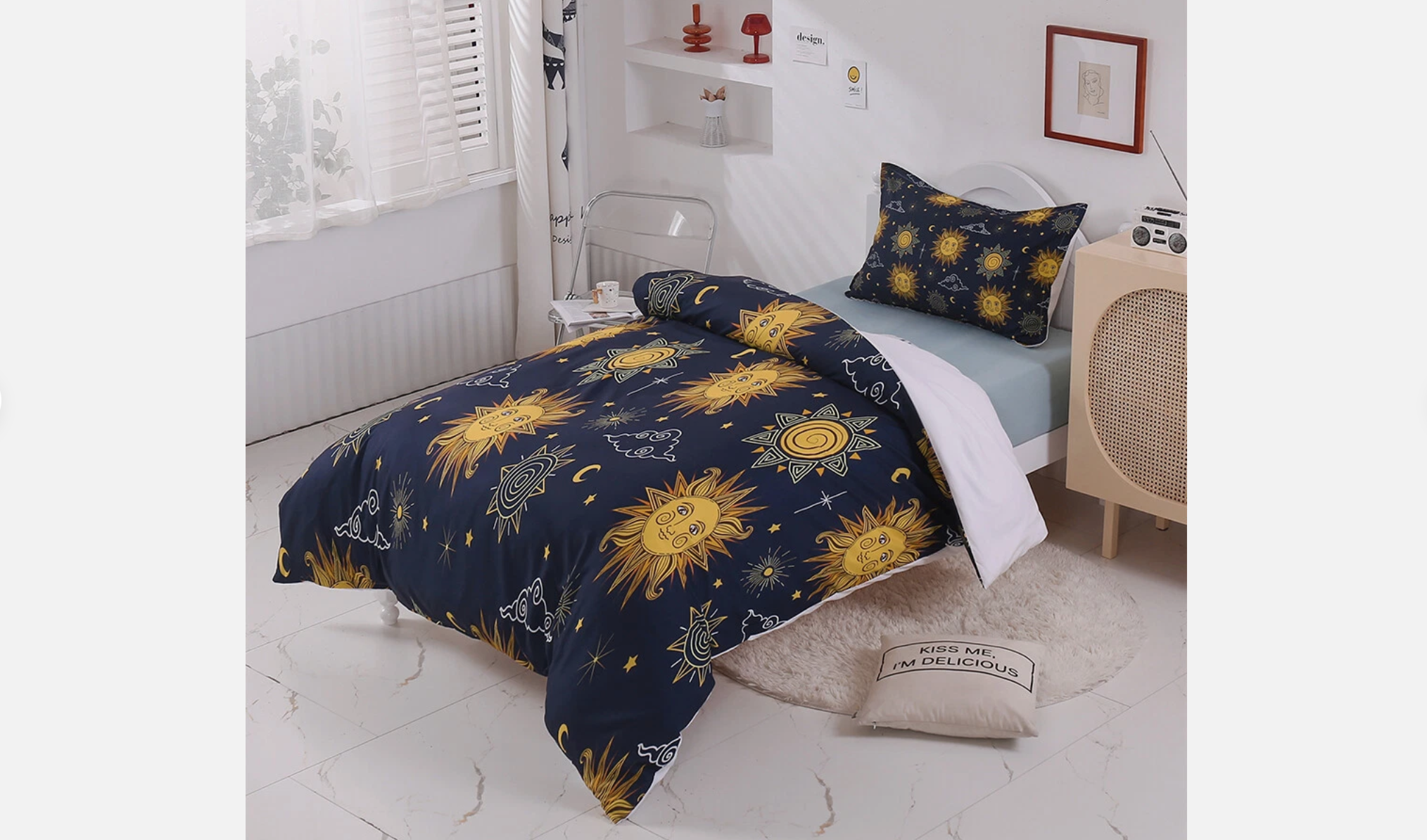 Navy blue bedding with vibrant yellow sun and moon illustrations, styled on a white bed with light blue fitted sheet and matching pillowcase