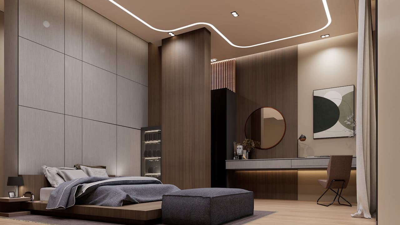 A contemporary bedroom interior with wood paneling walls, a low platform bed with gray bedding, a modern desk area with a round mirror, and minimalistic decor under soft ambient ceiling lighting