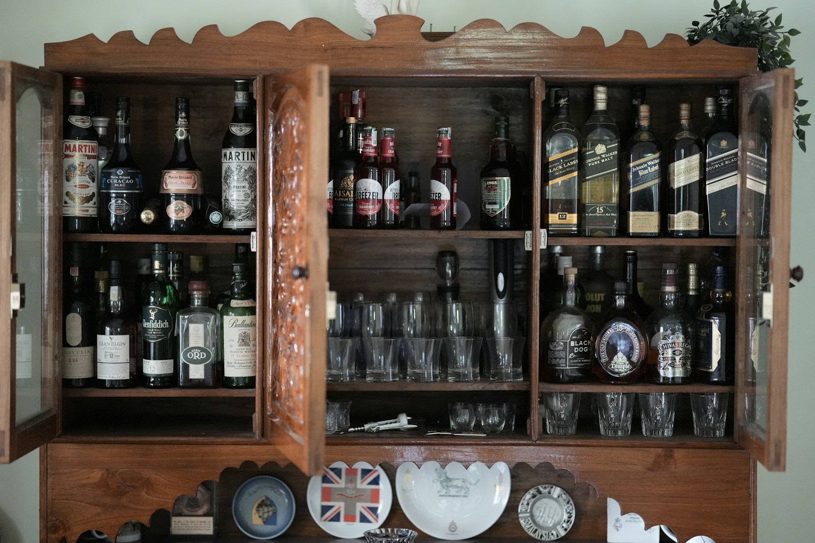 Wooden cabinet filled with bottles and glasses
