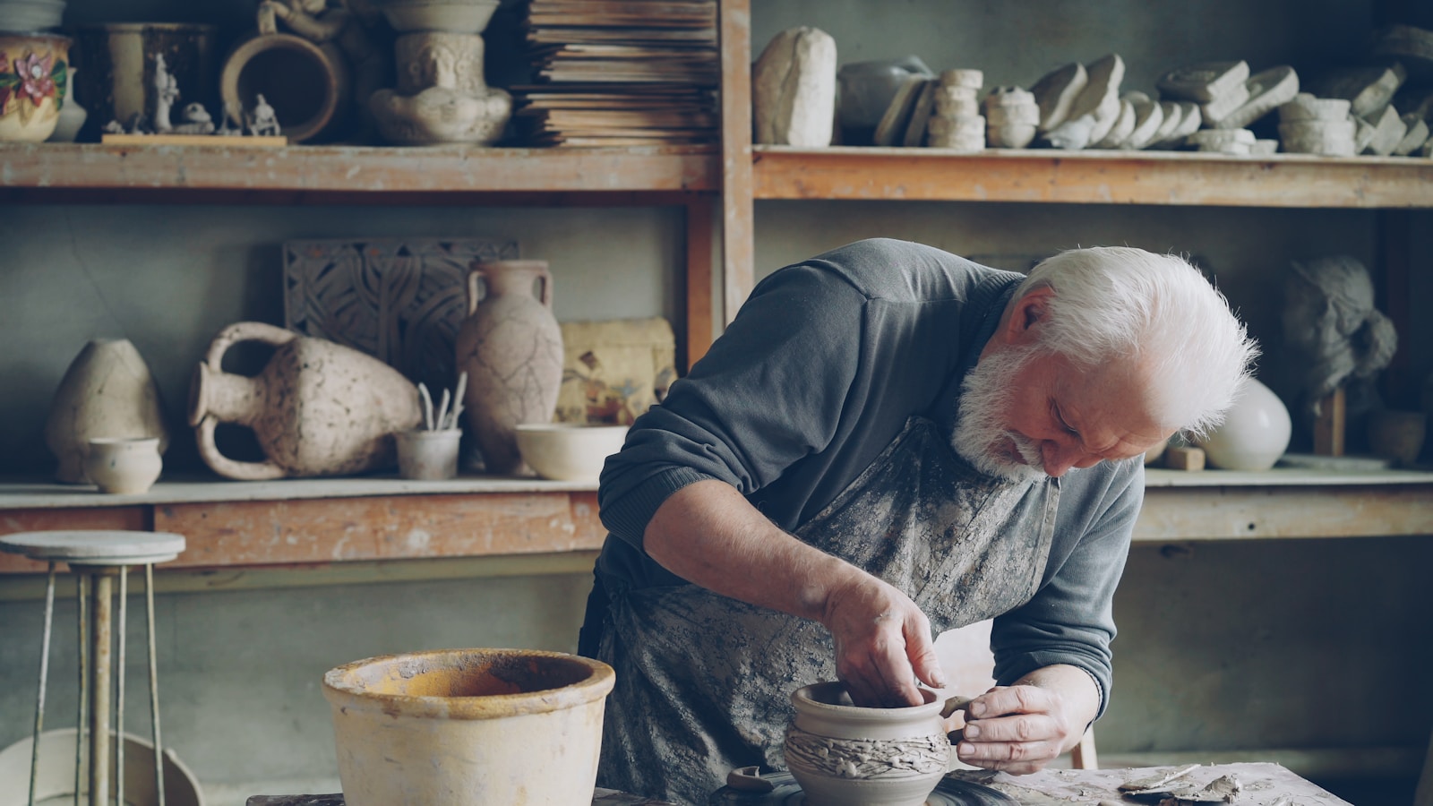 A potter works on a vase in his workshop.