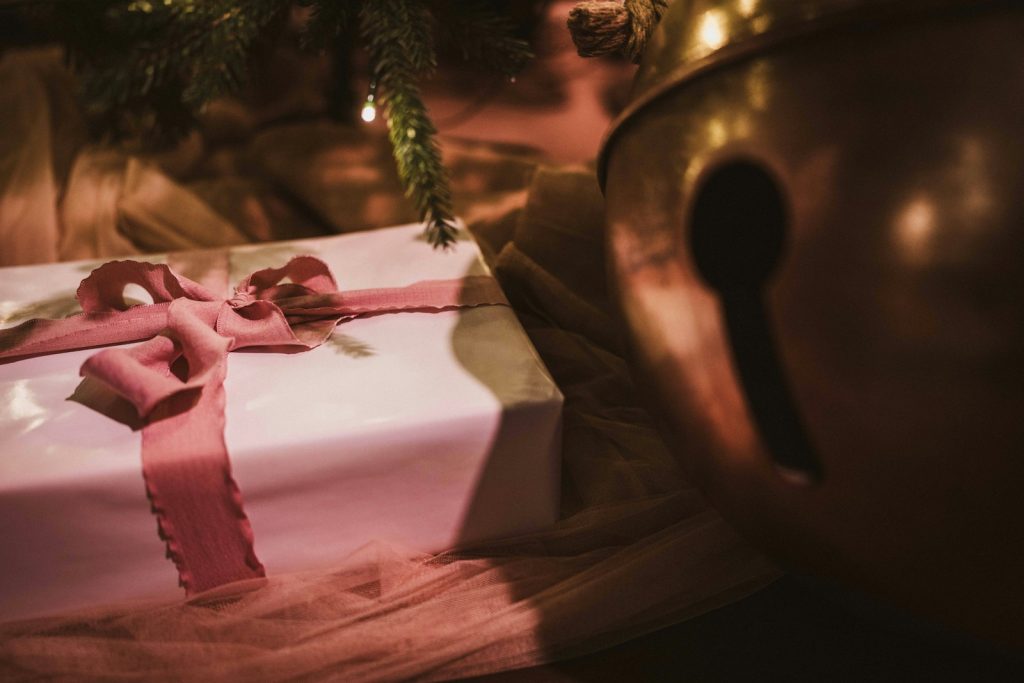 Christmas gift under tree with golden bell