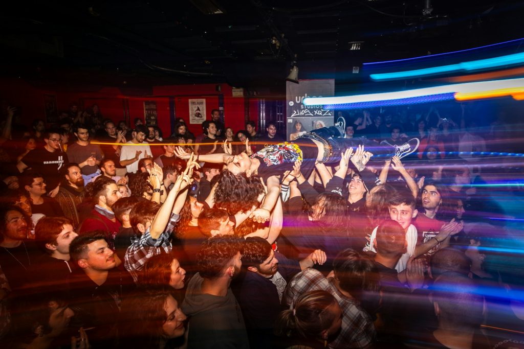 Crowd cheering at a concert with blurred lights
