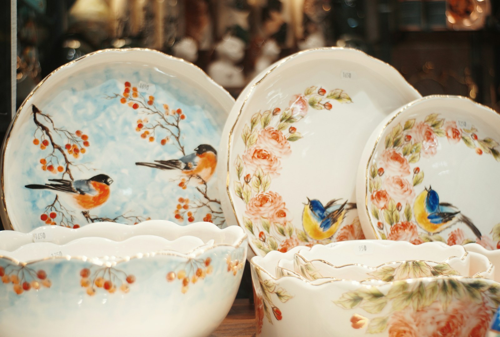 Ceramic plates and bowls with bird and floral designs.