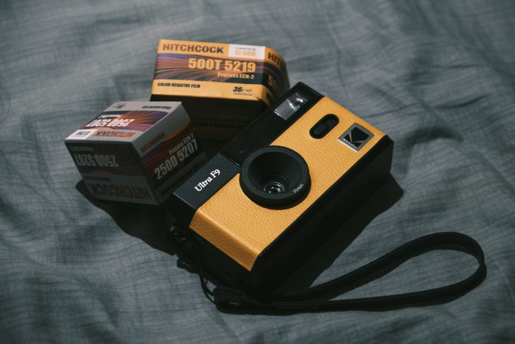 a yellow and black camera sitting on top of a bed