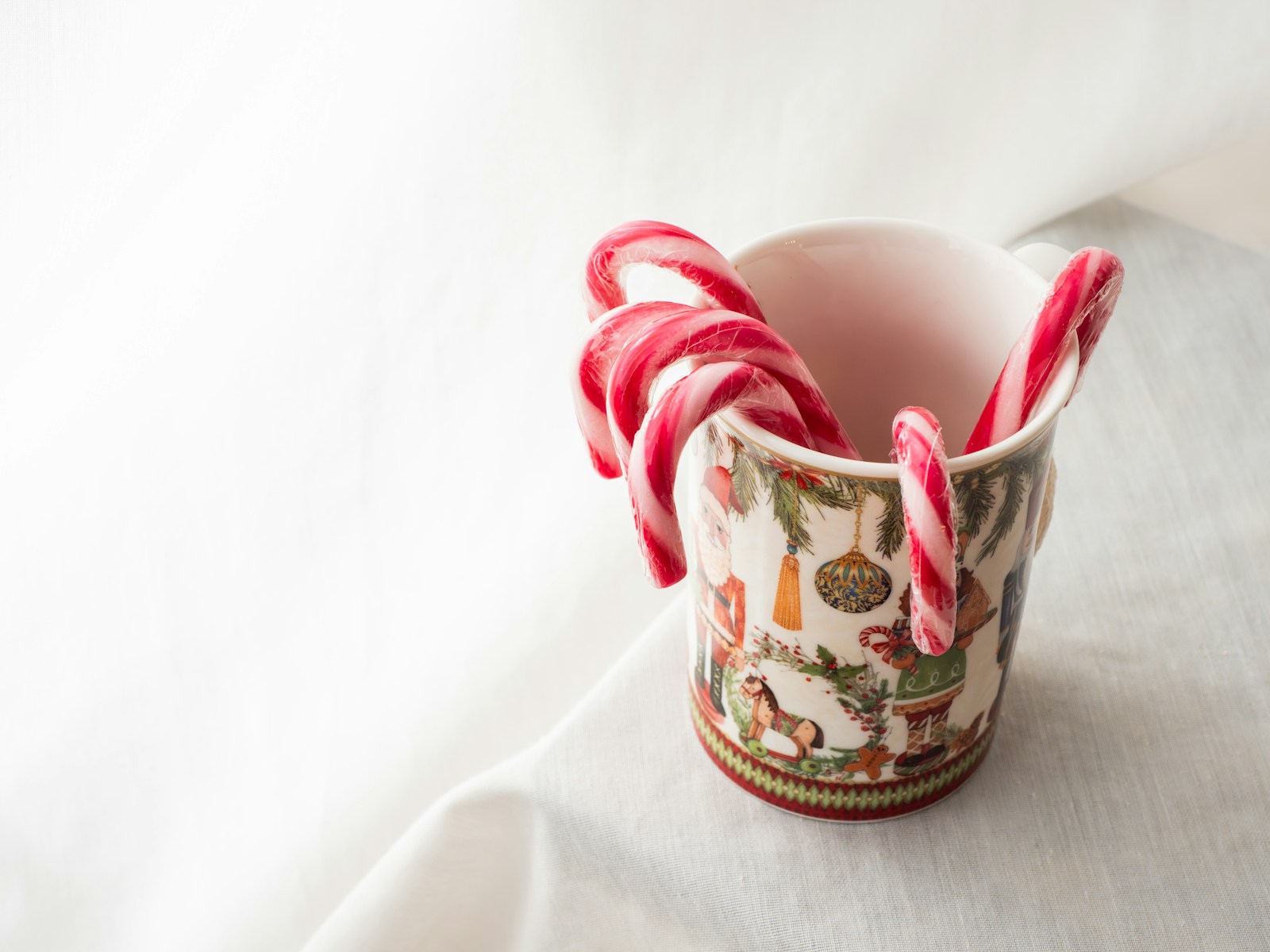 a cup with candy canes in it sitting on a table