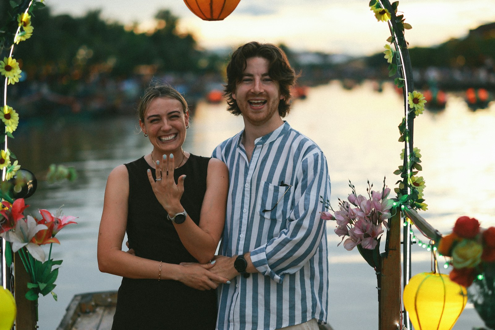 Couple celebrates engagement under an arch.