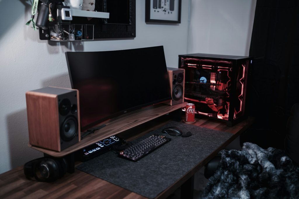 A desk with a laptop and speakers on it