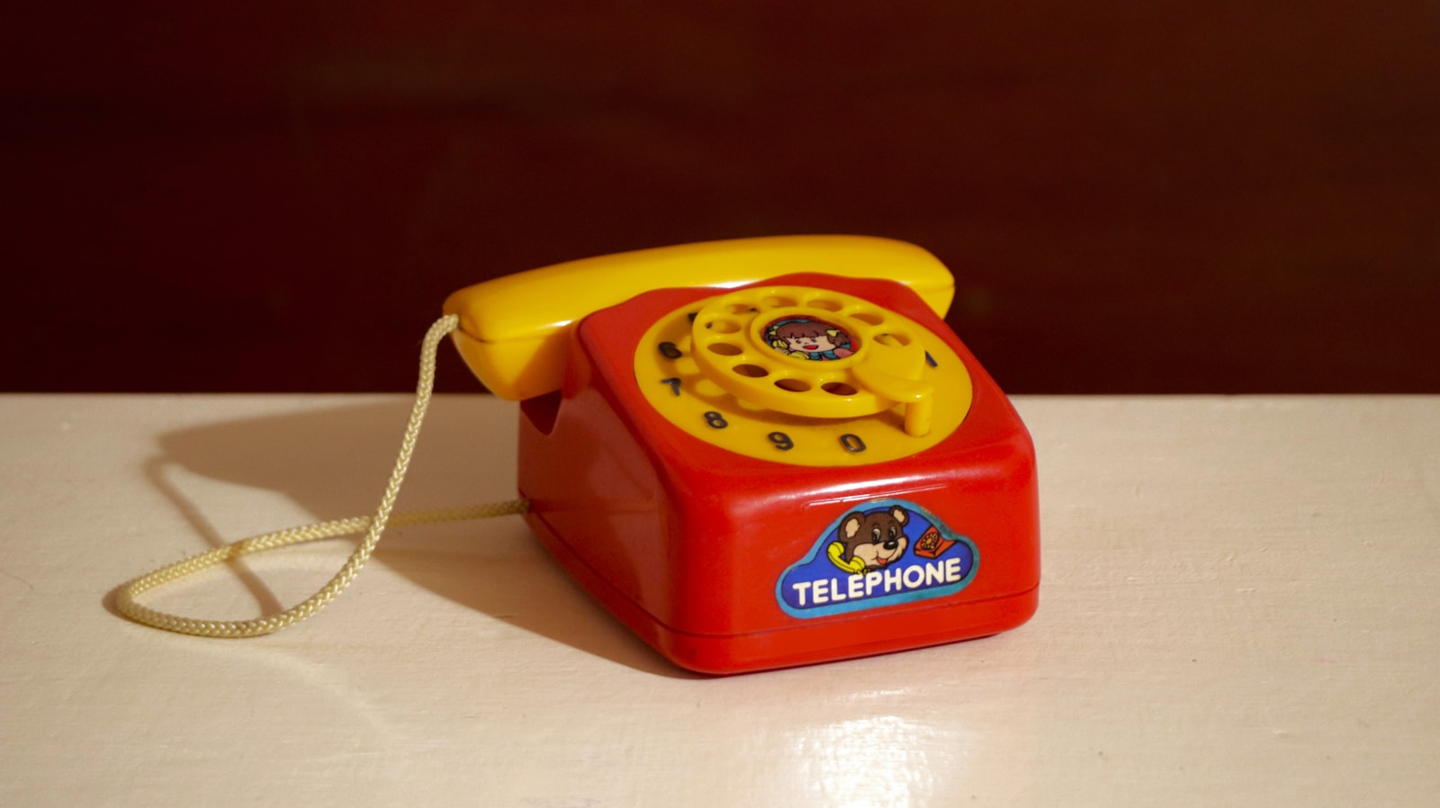 A bright red and yellow toy telephone.