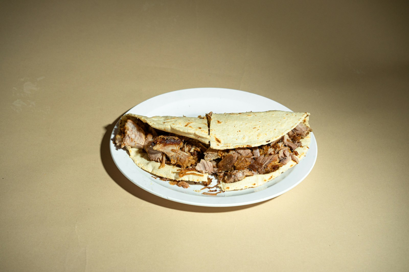 A white plate topped with a cut in half sandwich