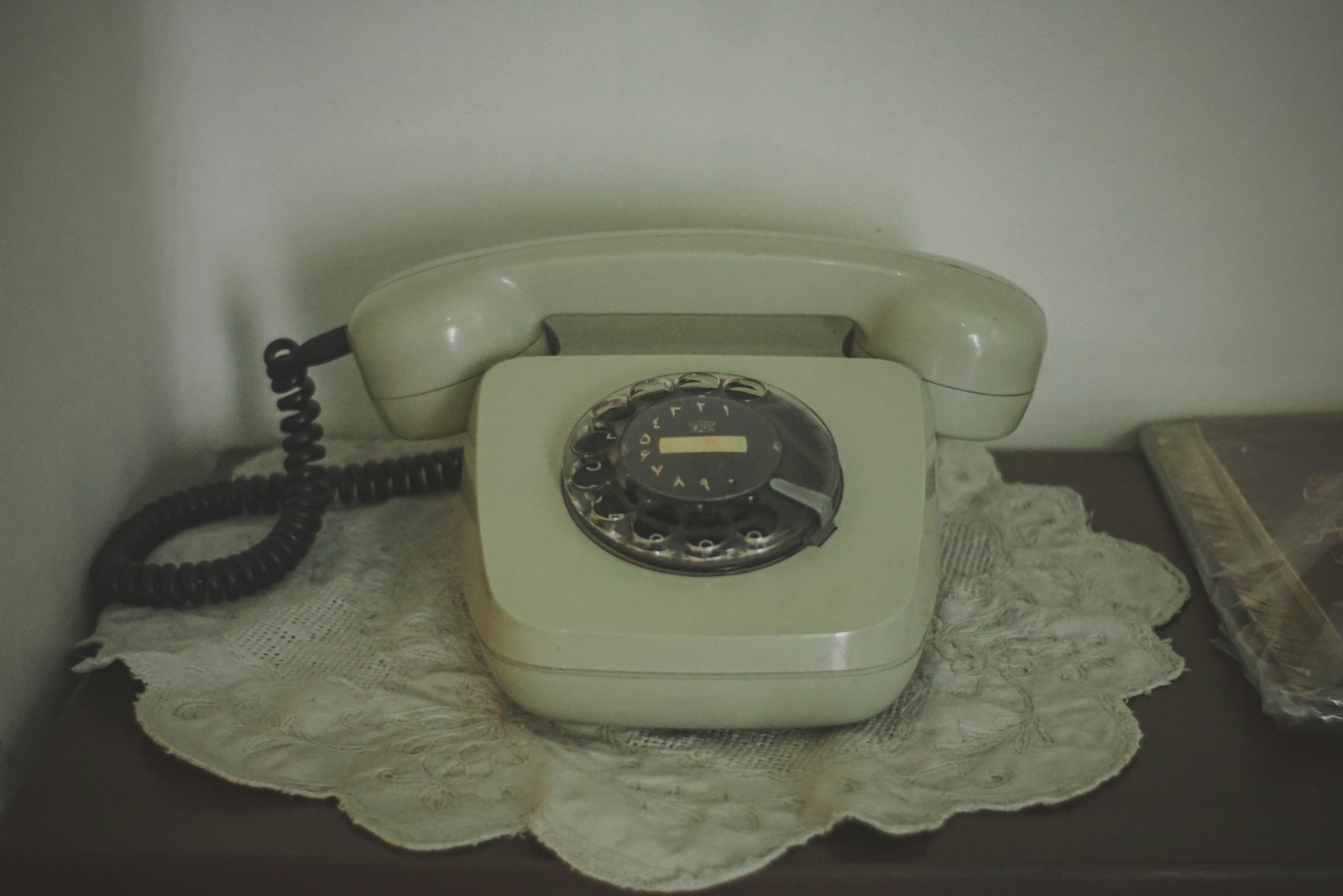 Vintage rotary dial telephone on a doily.