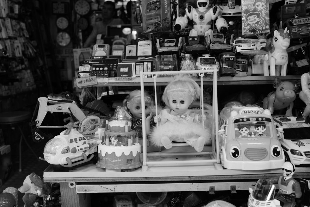 Assortment of vintage toys on shelves in a shop.