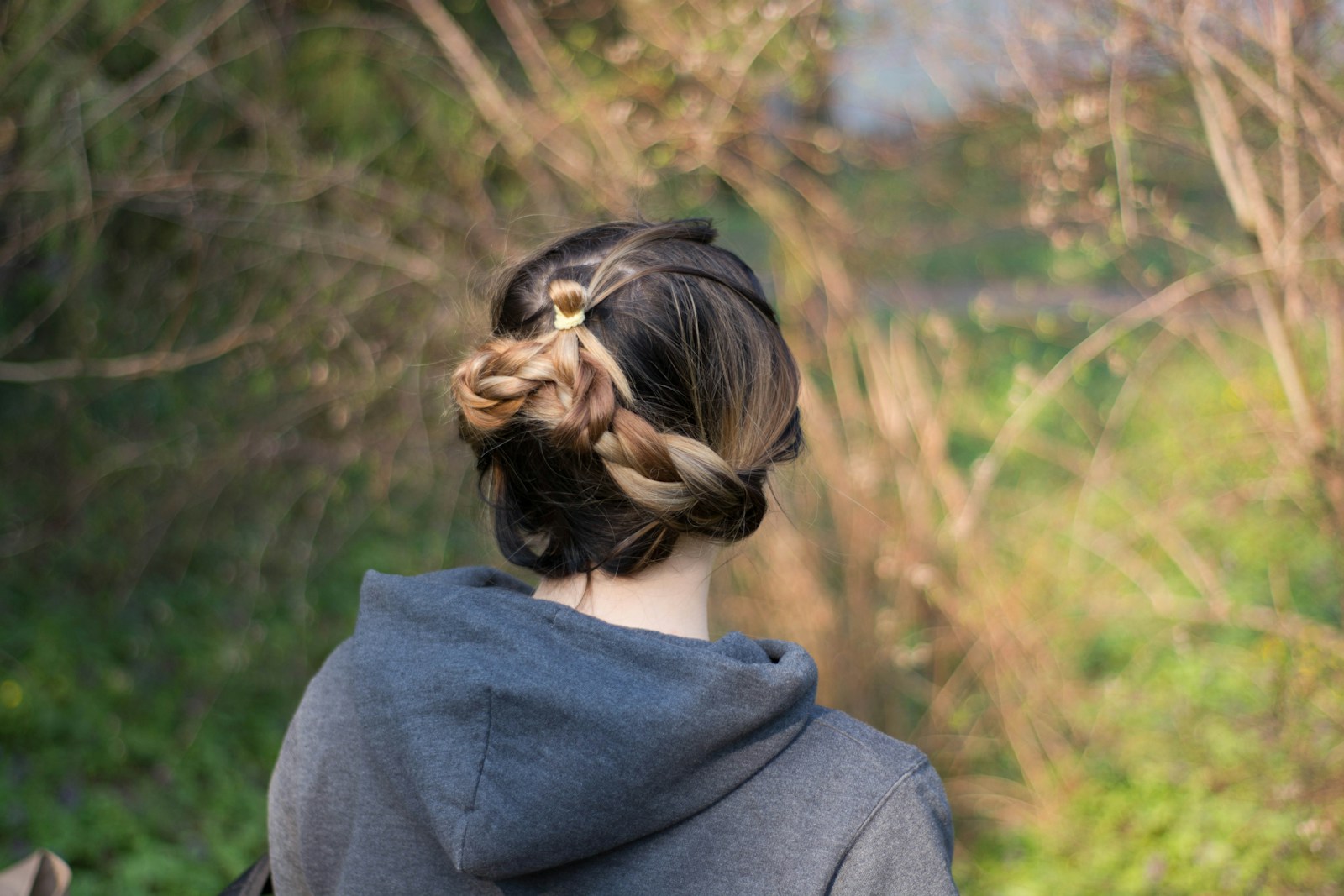 Woman with stylish braided hair looking outside.
