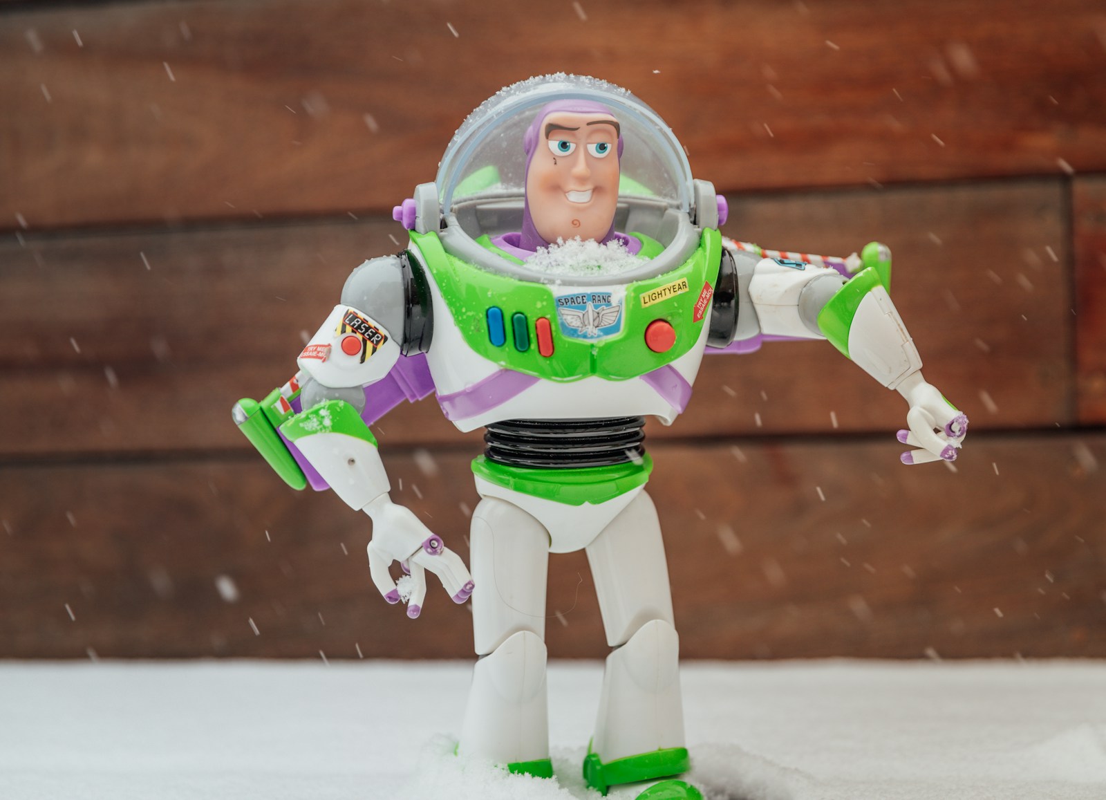 a toy buzz lightyear standing in the snow
