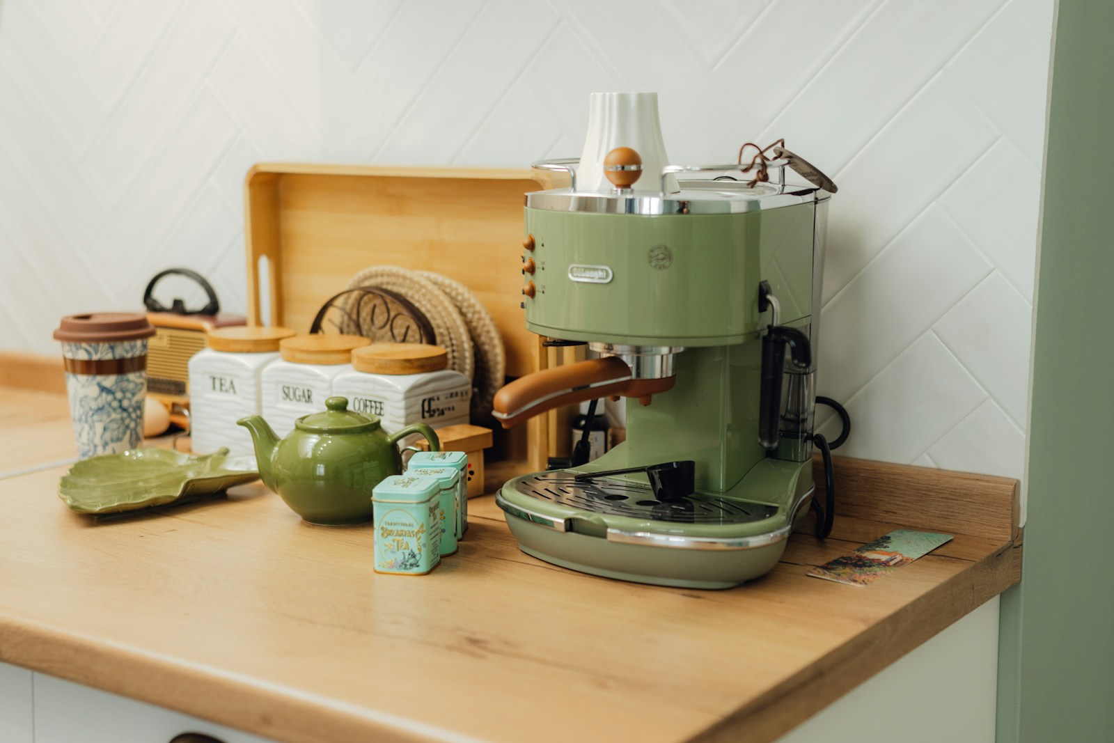 A green coffee maker sitting on top of a wooden counter