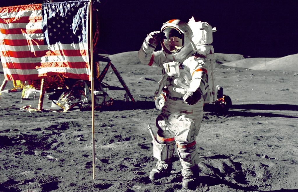 astronaut standing on moon beside U.S.A. flag