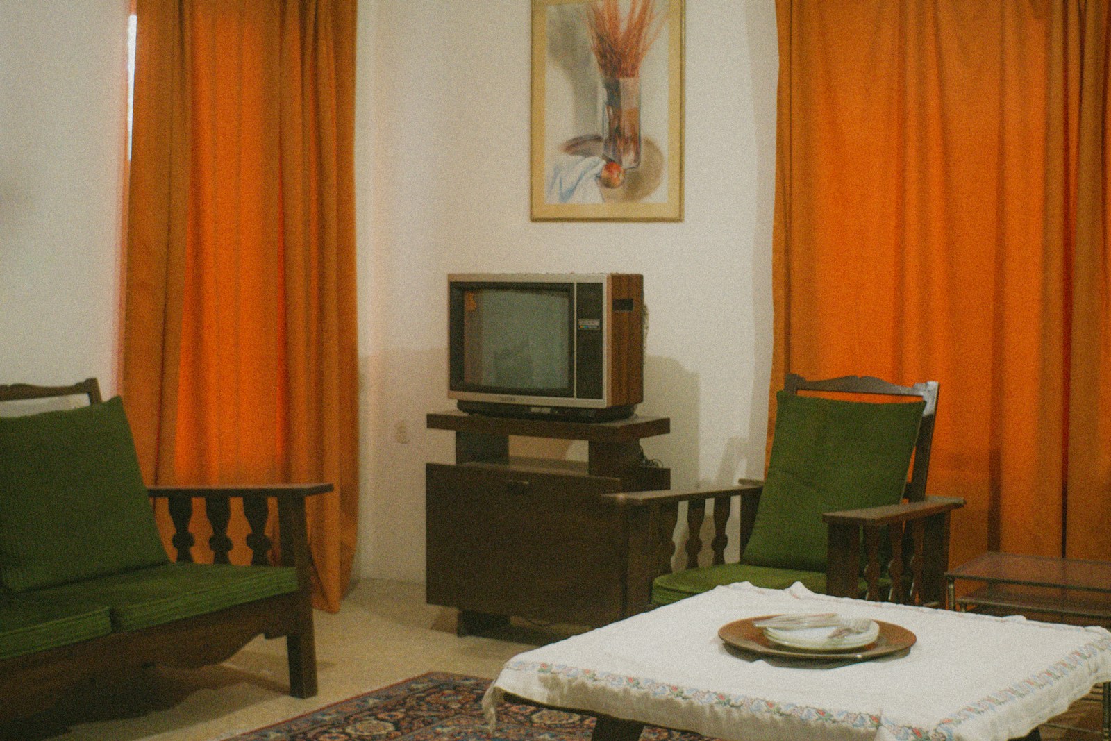Living room with vintage television and orange curtains