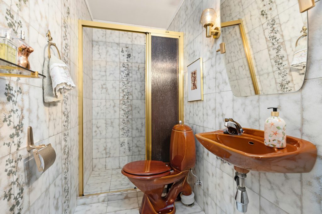 A bathroom with a toilet, sink and mirror