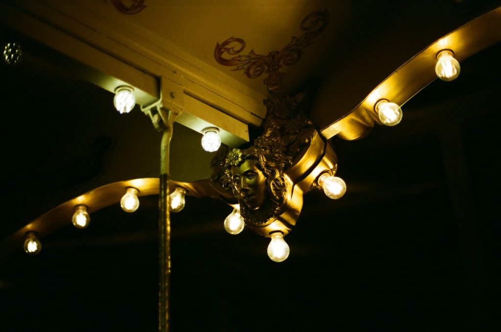 A golden chandelier illuminates a dark space.