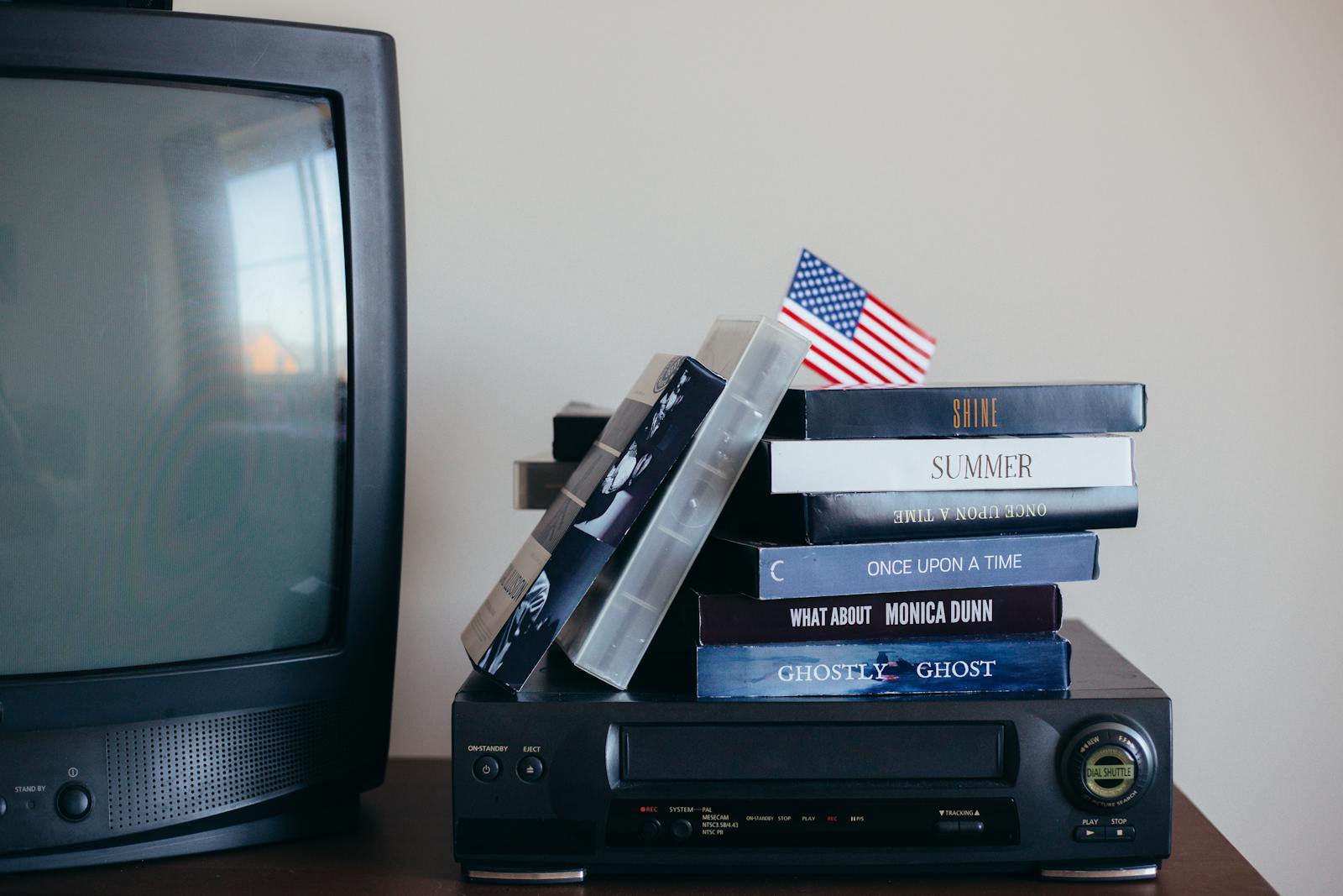 A nostalgic scene with VHS tapes, a vintage TV, and a small American flag.