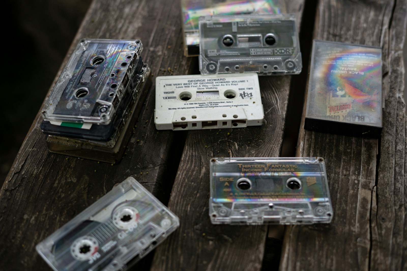 a group of cassettes sitting on top of a wooden table