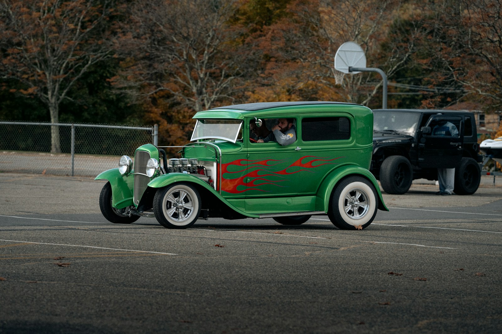 Green vintage car with flames on the side.