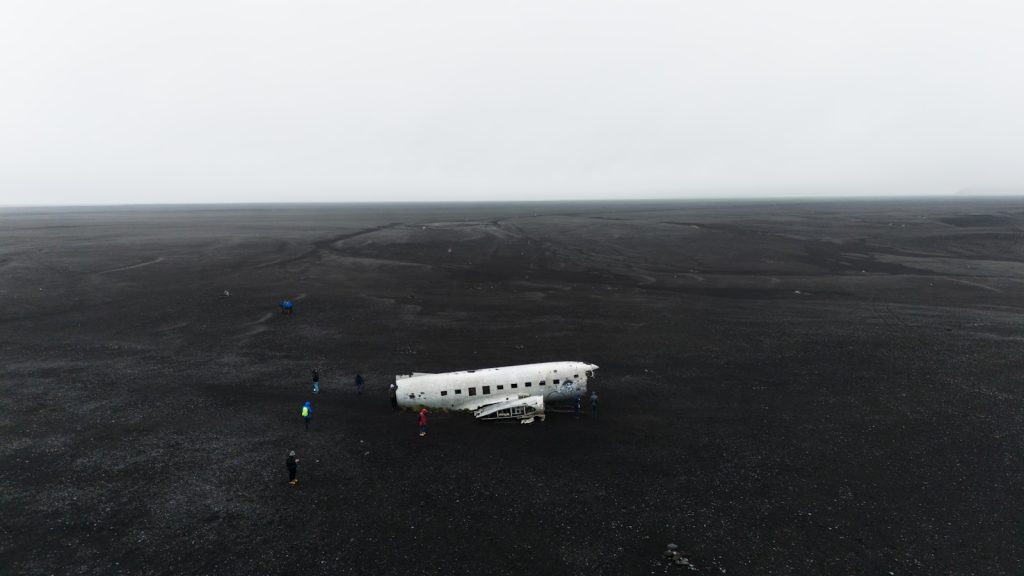 a small white airplane sitting on top of a black field