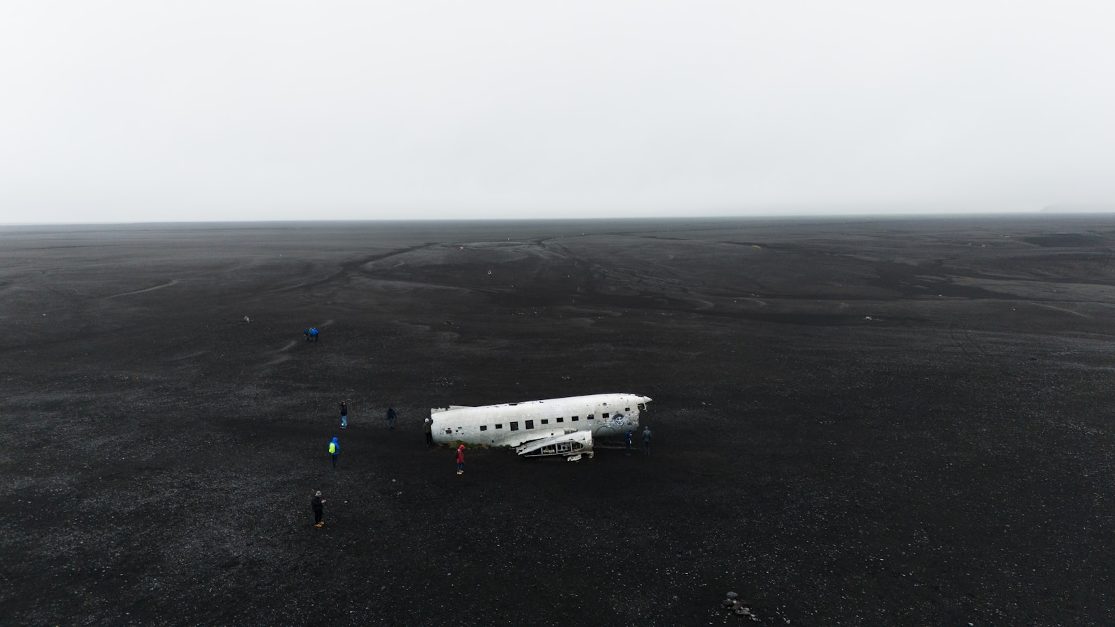a small white airplane sitting on top of a black field
