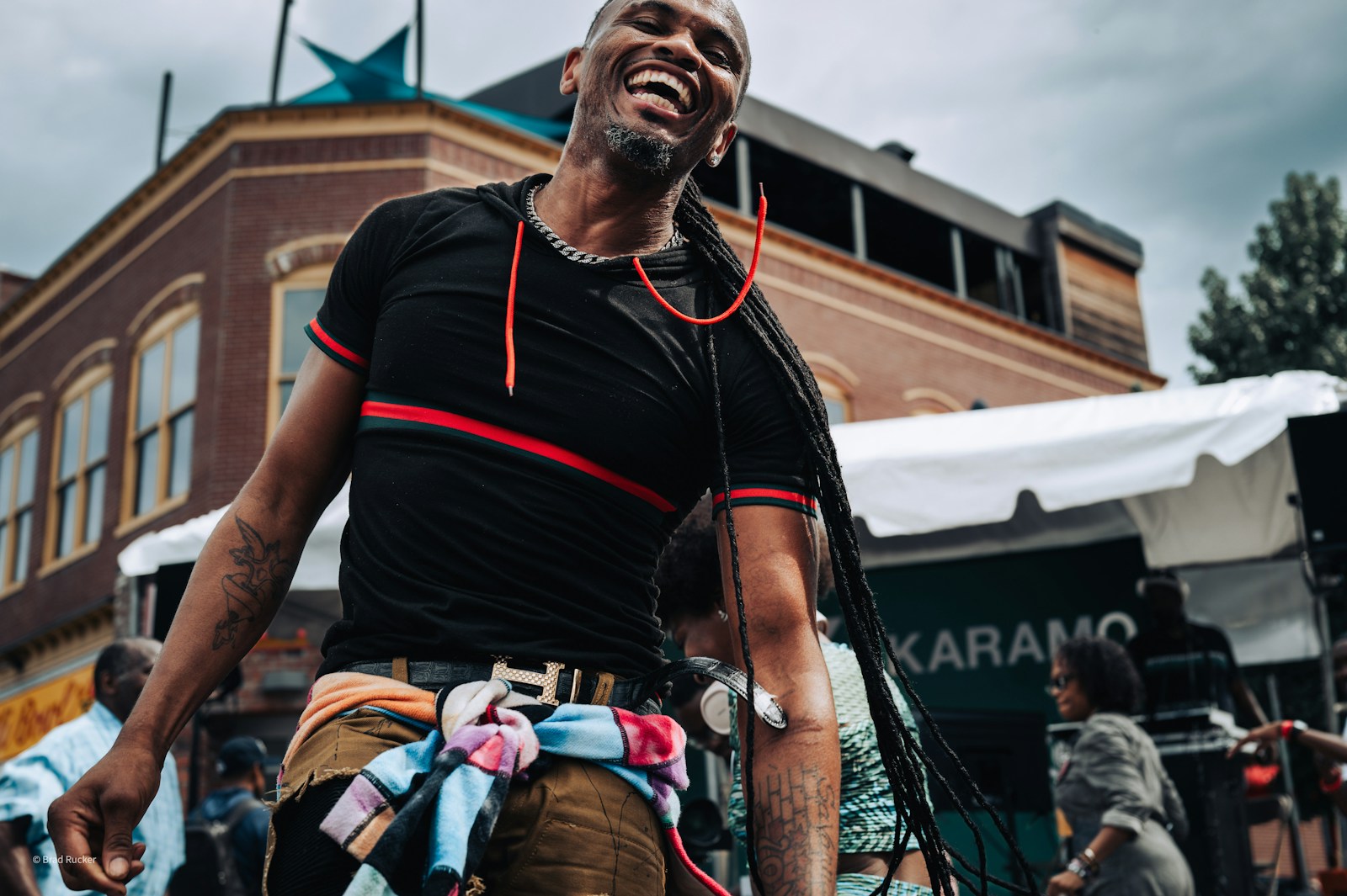 A man laughs heartily in an urban setting.