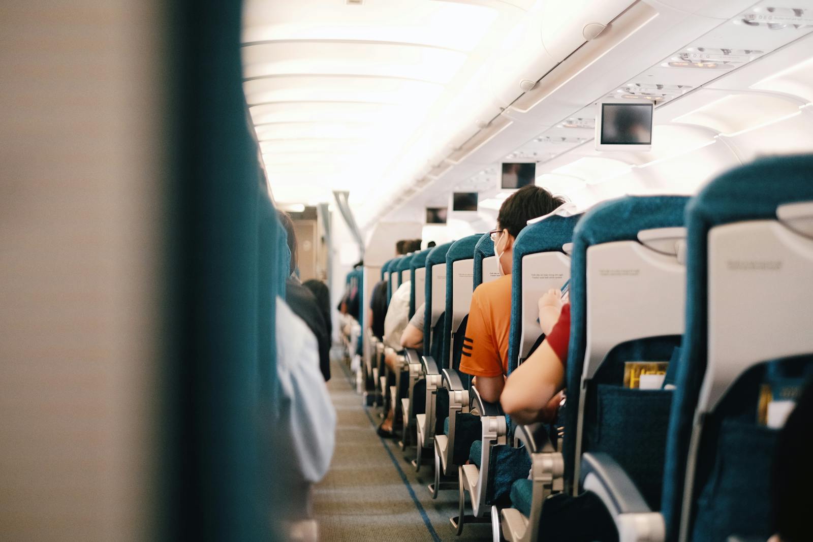 Interior view of airplane cabin showing passengers seated during a flight.