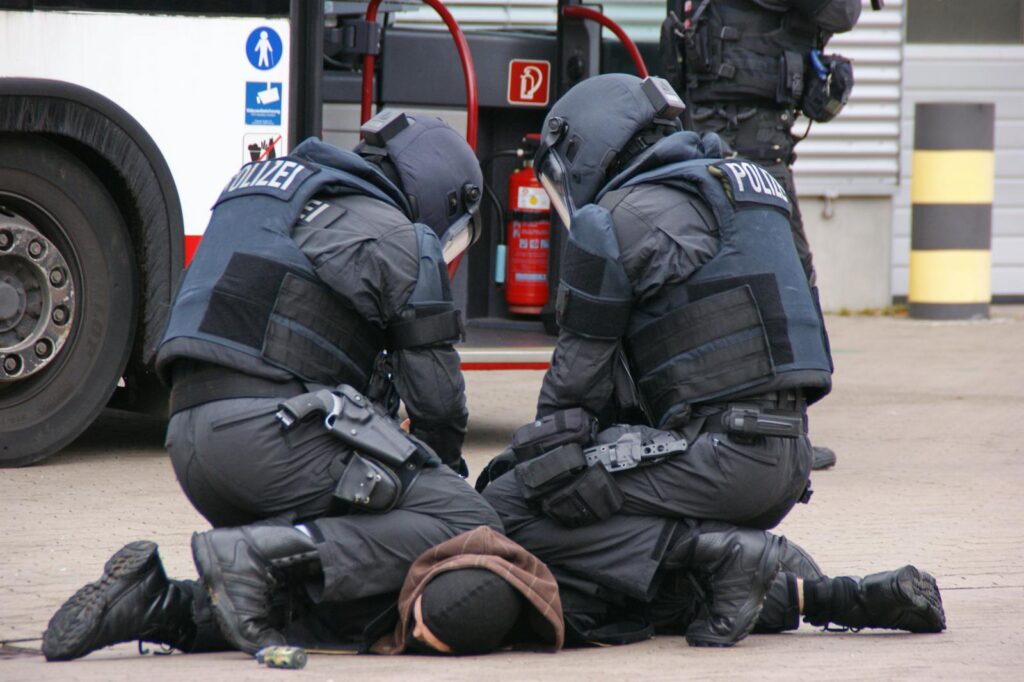 German police in full gear detain a suspect in an urban area in Hamburg.