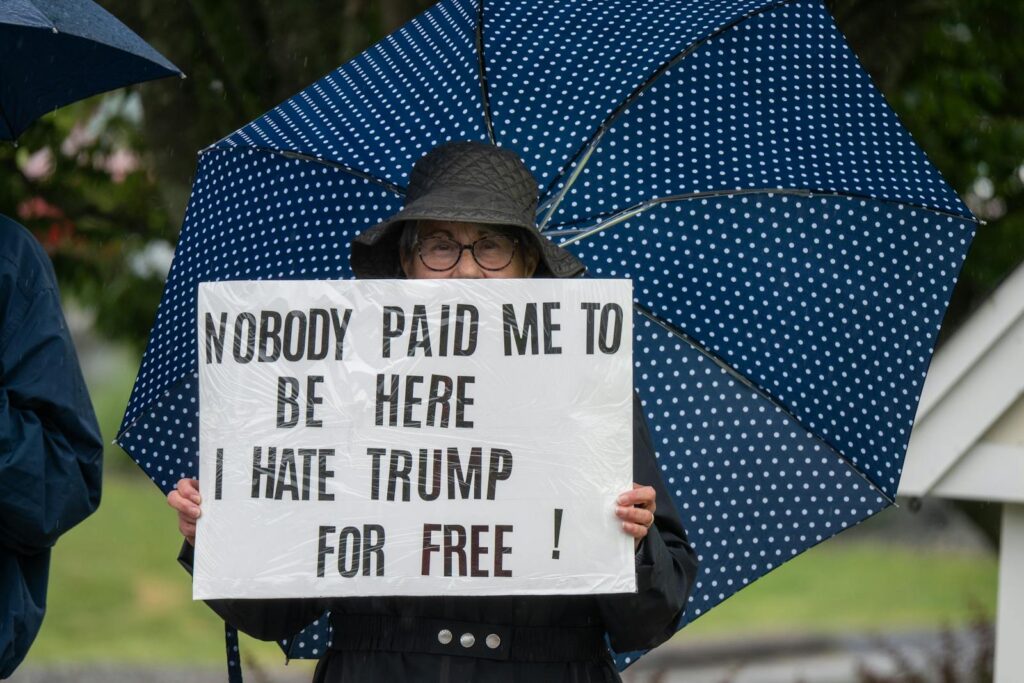 Protester with sign and umbrella during a rally in Rhode Island.