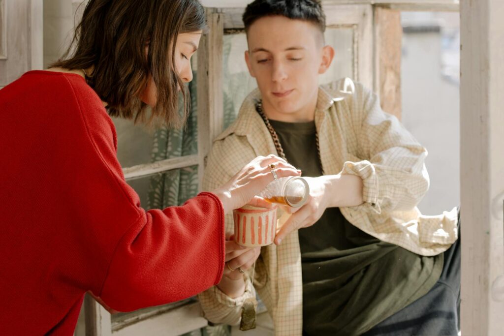 A young couple sharing tea by a window, evoking warmth and companionship indoors.