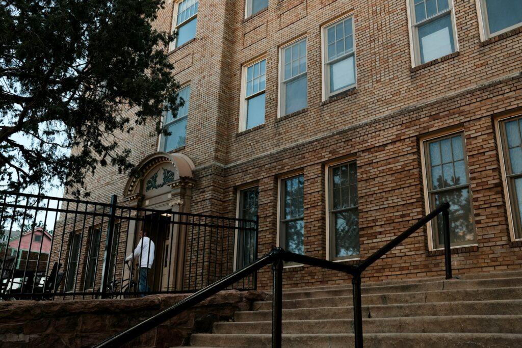 a man walking up a set of stairs in front of a brick building