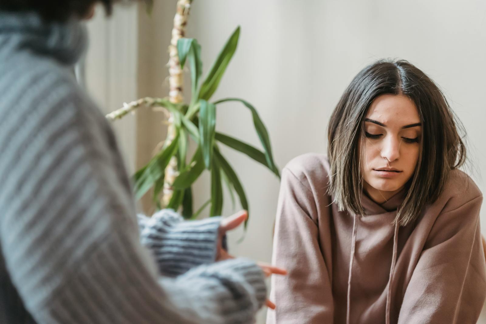 Two women having an intense and serious conversation at home, conveying emotions of frustration and concern.