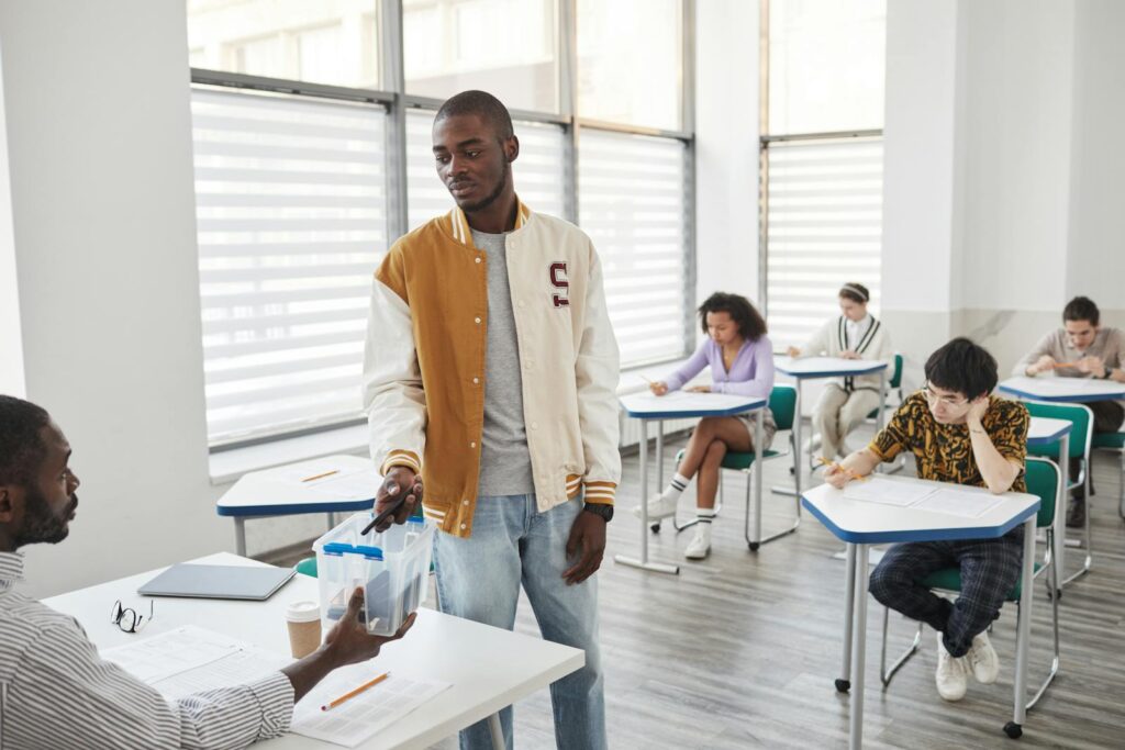 Group of students taking exams in a modern classroom setting.
