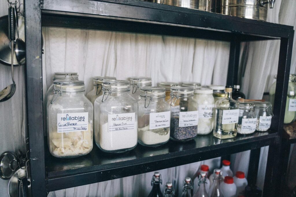 Organized glass jars on a pantry shelf for eco-friendly food storage and sustainability.