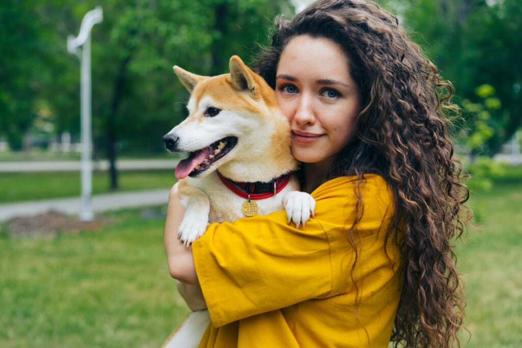 a woman holding a dog in a park
