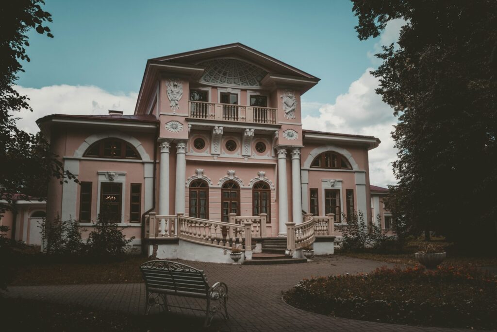 a large pink house with a staircase leading up to it