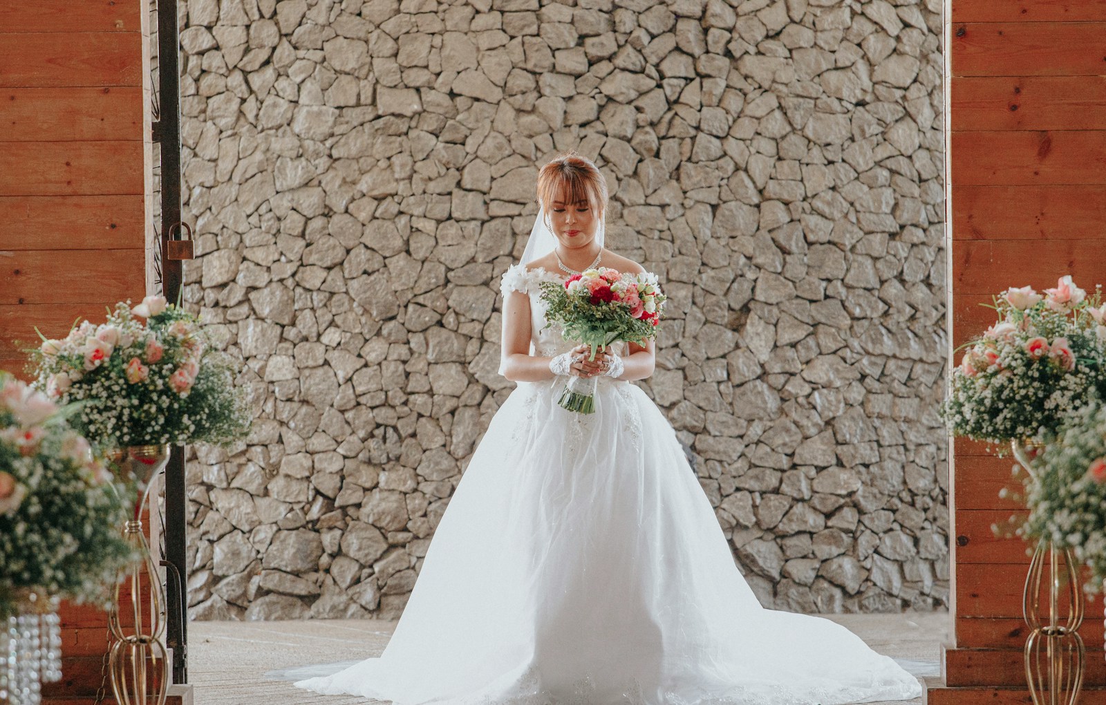 woman in white wedding dress holding bouquet of flowers