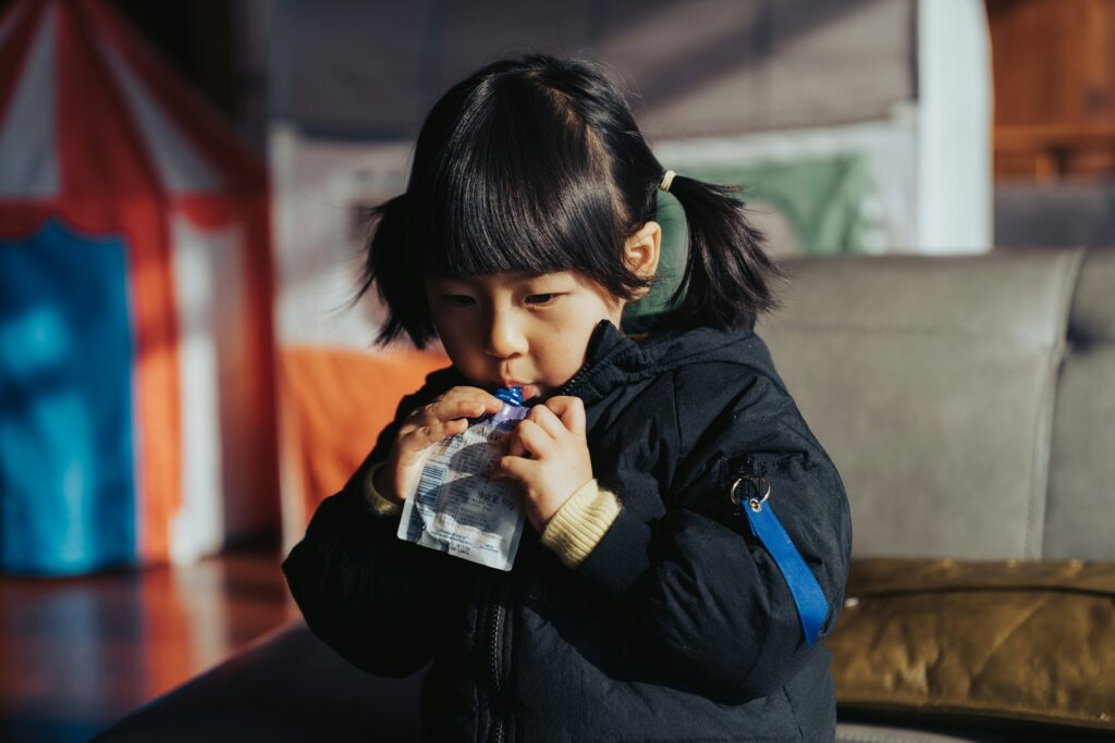 a little girl drinking from a plastic bottle