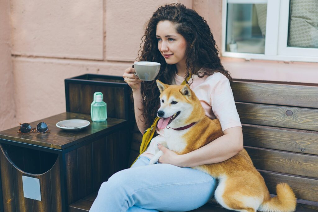 a woman sitting on a bench with a dog on her lap