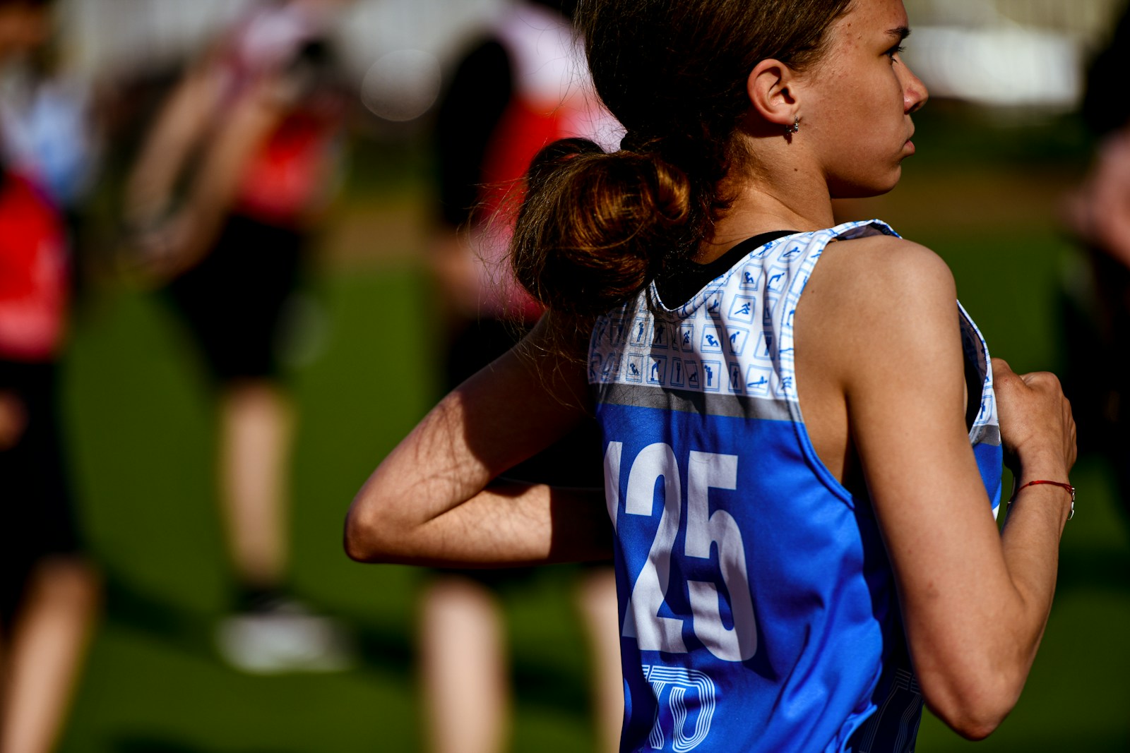 a woman running in a race with other people in the background