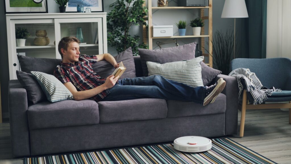 a man laying on a couch reading a book