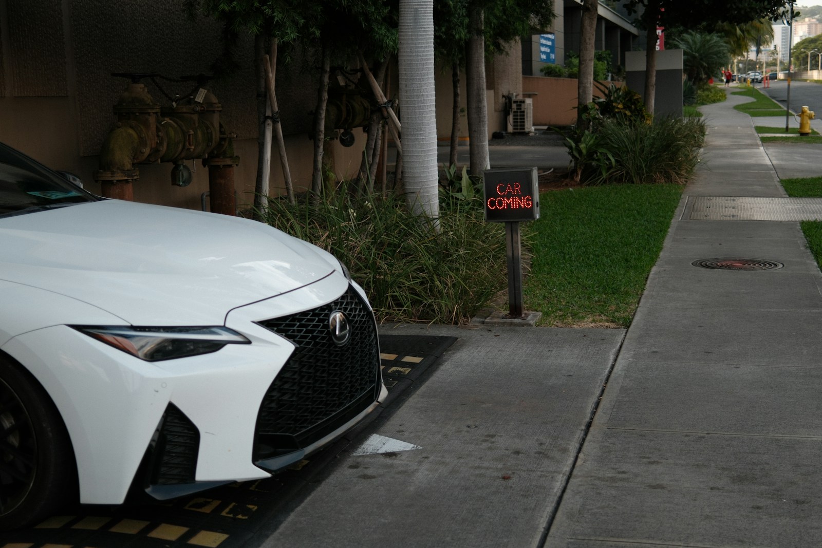 White car parked by a sidewalk and mailbox.
