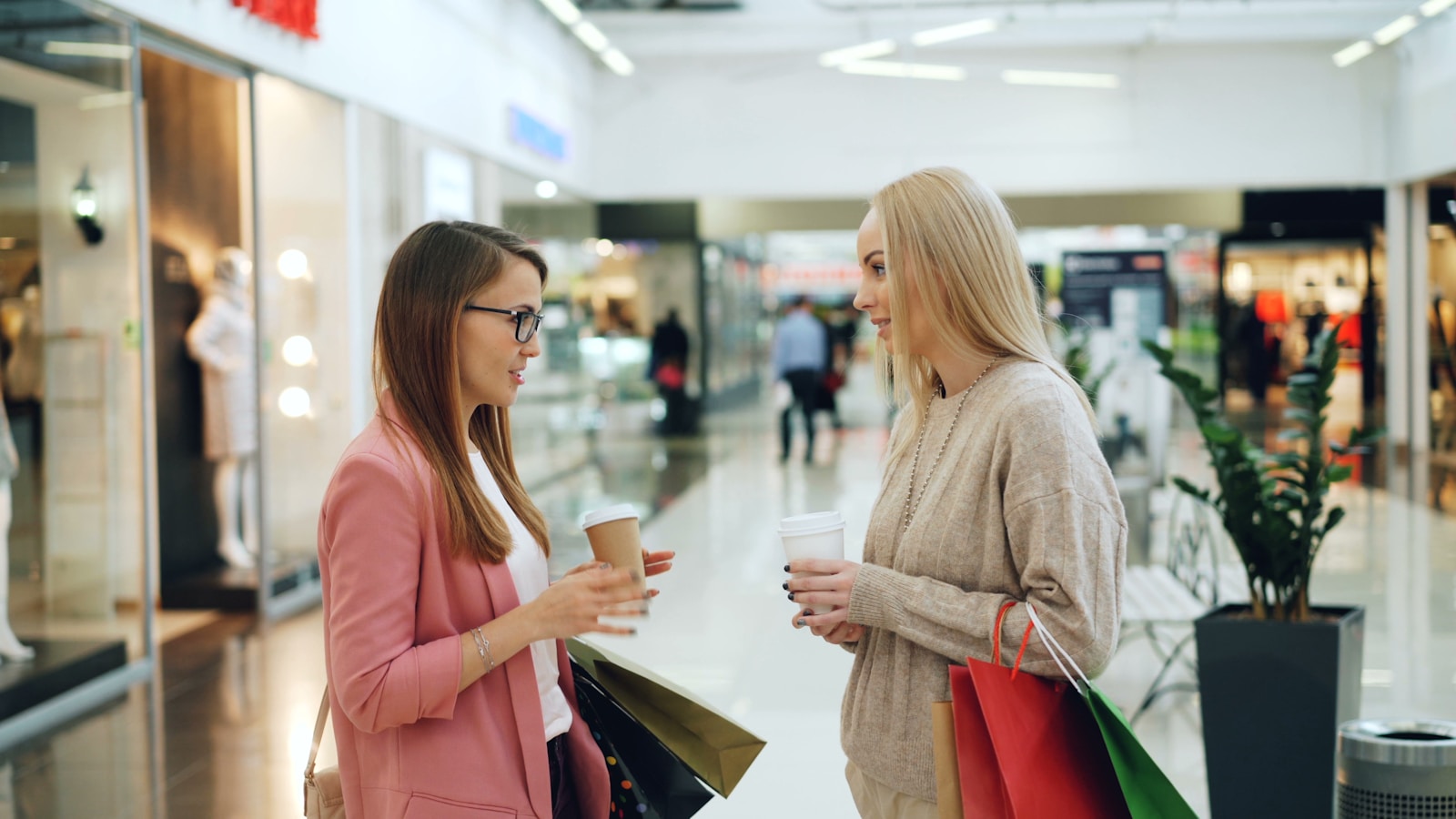 Two women talking in a shopping mall.