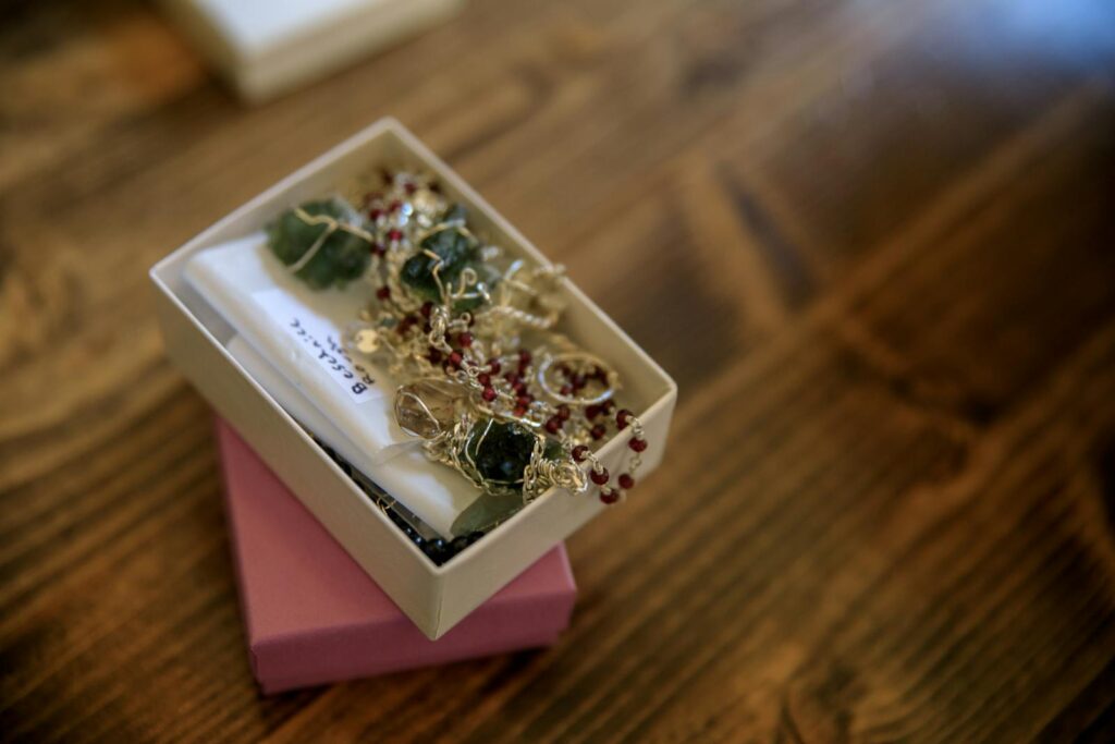 Close-up of handmade gemstone jewelry in a gift box, showcasing intricate craftsmanship and design.
