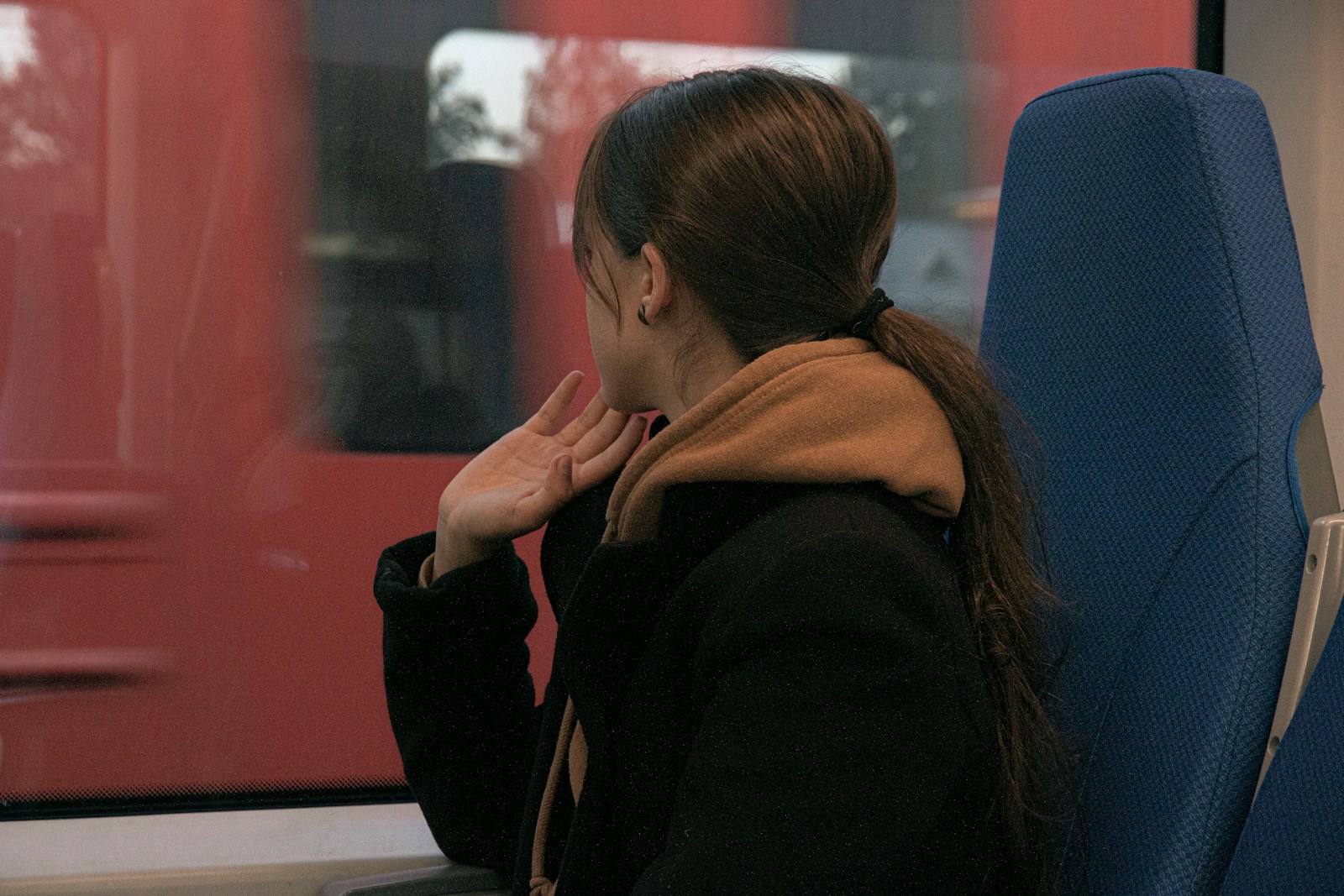 woman in black jacket sitting on blue chair