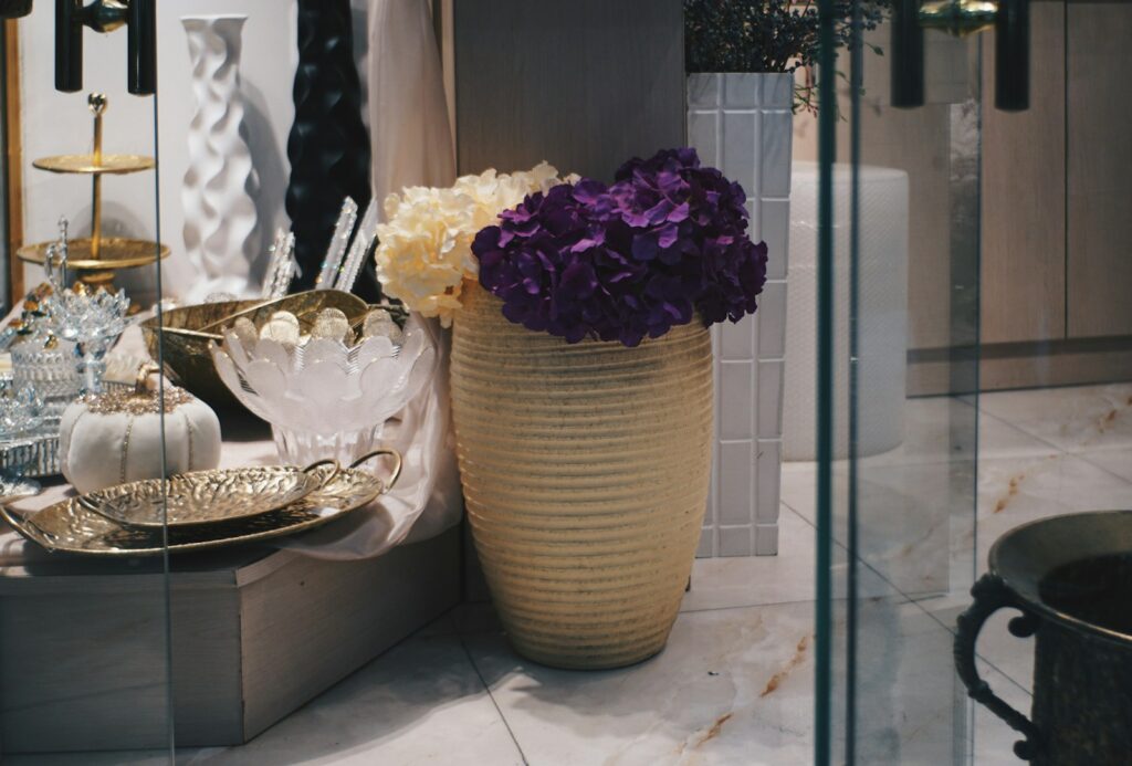 Vase with purple and white flowers on a shelf