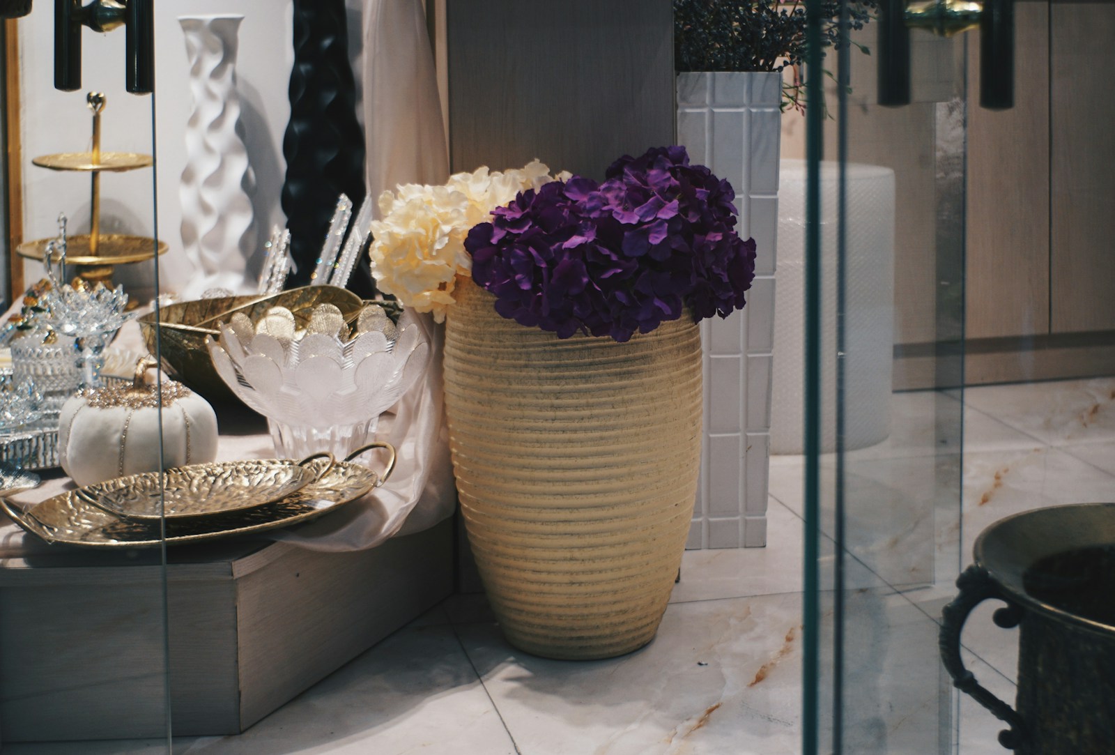Vase with purple and white flowers on a shelf